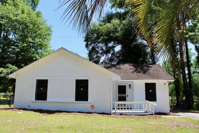 view of front of home featuring brick siding, roof with shingles, and a porch
