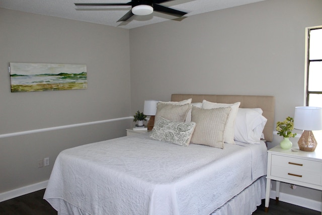 bedroom featuring dark wood-style floors, baseboards, and ceiling fan