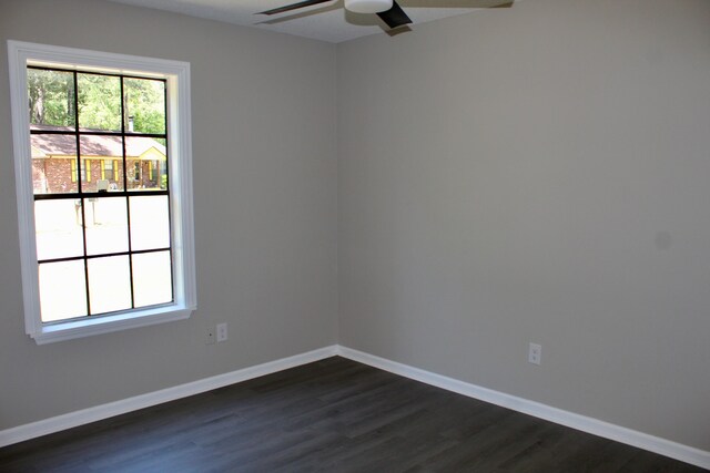 unfurnished room with dark wood-type flooring, ceiling fan, and baseboards