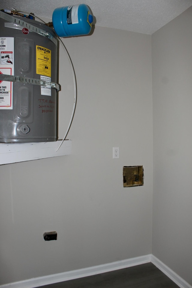 laundry room featuring a textured ceiling, baseboards, dark wood finished floors, and washer hookup