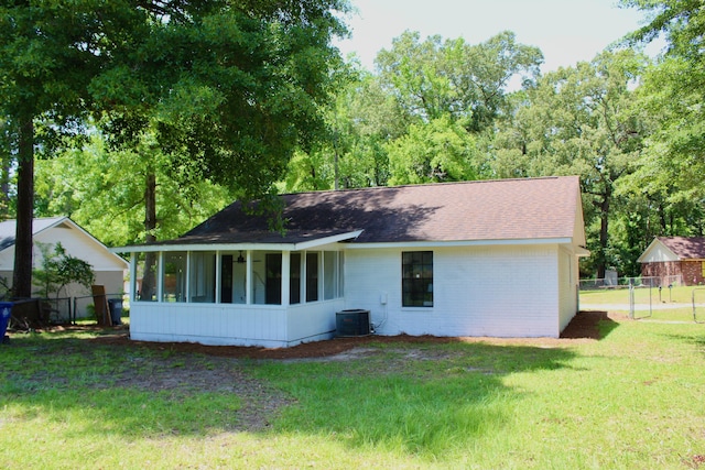 back of property featuring a sunroom, roof with shingles, and cooling unit