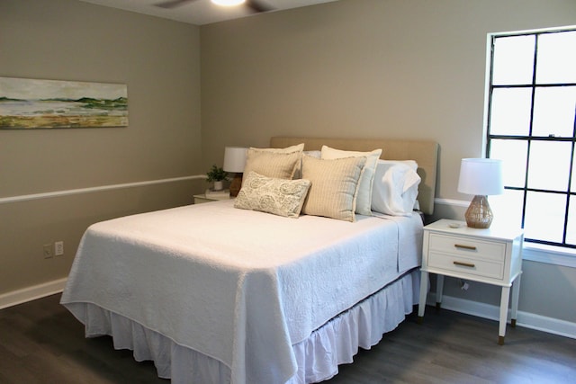 bedroom with dark wood-type flooring and baseboards
