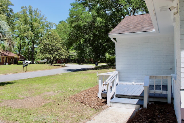 view of grassy yard with a deck