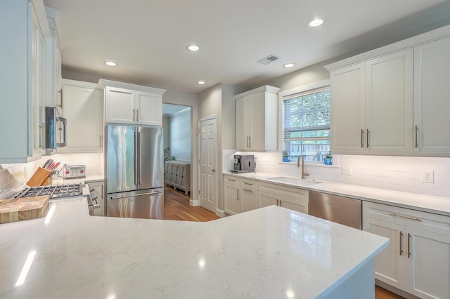 2150 Terrabrook Ln, Charleston, SC 29412 - kitchen with stainless steel appliances, tasteful backsplash, recessed lighting, light stone countertops, and white cabinetry
