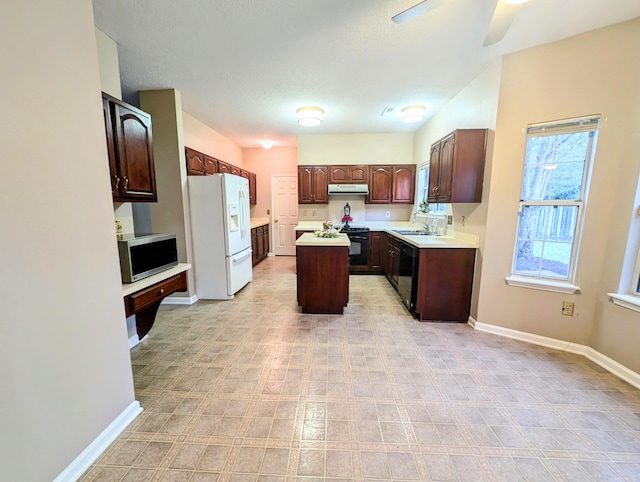 kitchen featuring dark brown cabinetry, ceiling fan, a center island, sink, and black appliances