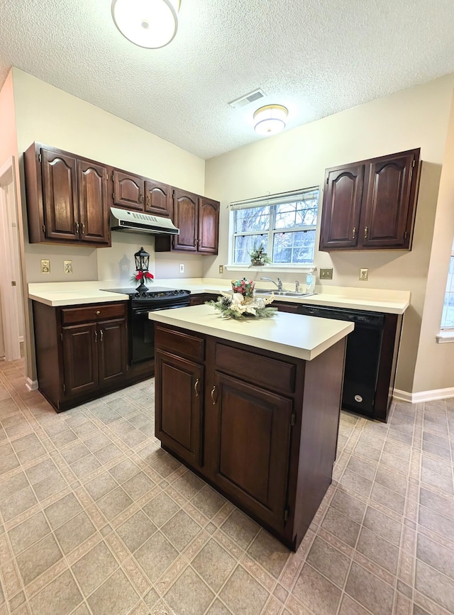 kitchen featuring dark brown cabinets, a textured ceiling, sink, black appliances, and a kitchen island