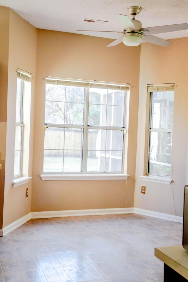 spare room with plenty of natural light and ceiling fan