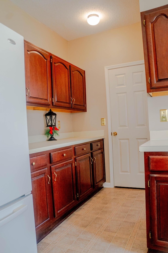 kitchen featuring white fridge and a textured ceiling