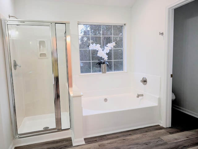 bathroom with hardwood / wood-style flooring and independent shower and bath