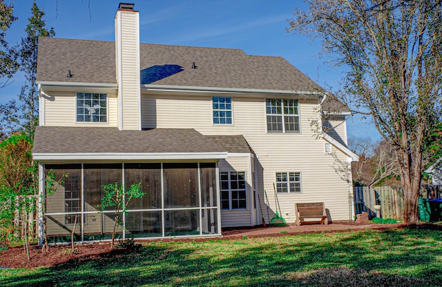 rear view of house featuring a lawn and a sunroom