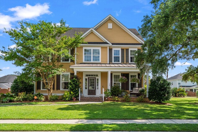 129 Saluda Dr, Moncks Corner, SC 29461 - traditional home featuring covered porch, a front yard, a standing seam roof, and a metal roof