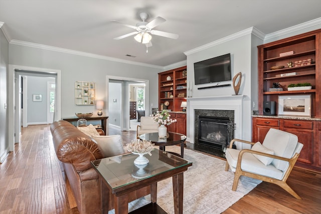 129 Saluda Dr, Moncks Corner, SC 29461 - living room featuring ceiling fan, light wood-style flooring, a high end fireplace, ornamental molding, and built in features