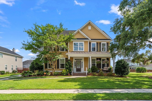 129 Saluda Dr, Moncks Corner, SC 29461 - traditional-style house featuring a standing seam roof, a front lawn, covered porch, and a metal roof