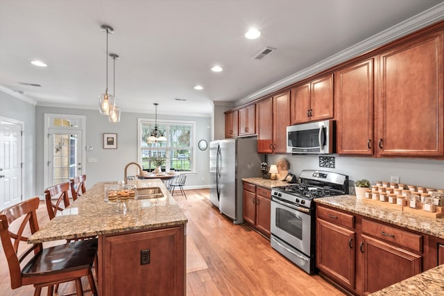 129 Saluda Dr, Moncks Corner, SC 29461 - kitchen with appliances with stainless steel finishes, ornamental molding, a kitchen breakfast bar, light wood-style floors, and light stone counters