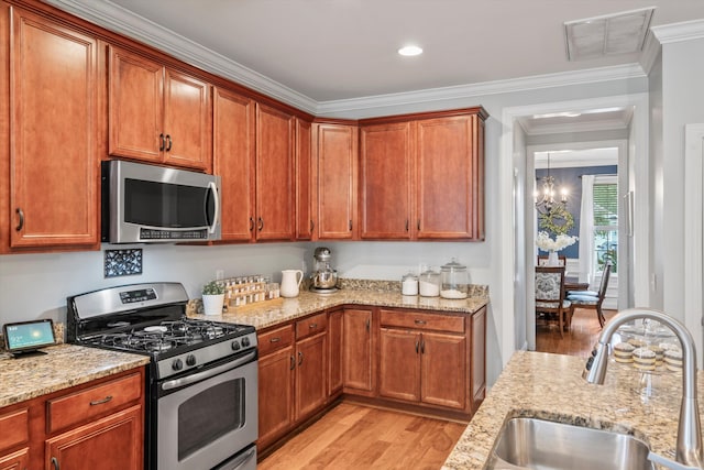 129 Saluda Dr, Moncks Corner, SC 29461 - kitchen with appliances with stainless steel finishes, light wood-style floors, light stone countertops, a chandelier, and crown molding
