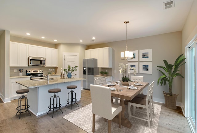 dining area featuring sink and light hardwood / wood-style floors