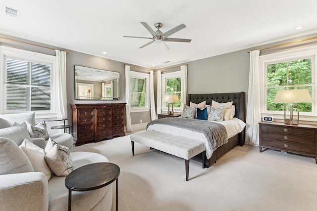 carpeted bedroom with ornamental molding and ceiling fan