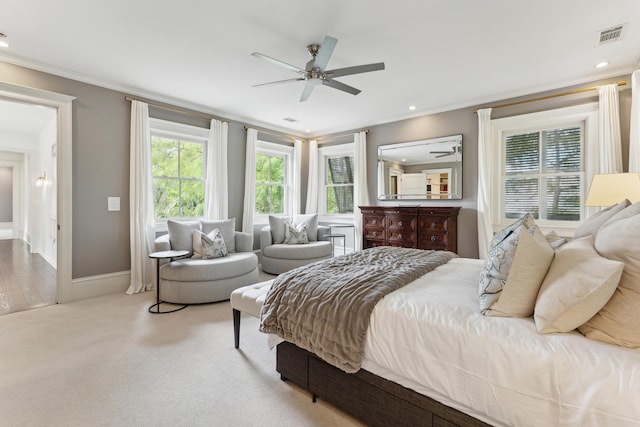 carpeted bedroom with ornamental molding and ceiling fan