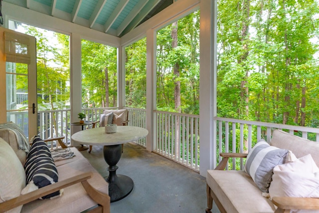 sunroom featuring lofted ceiling and plenty of natural light