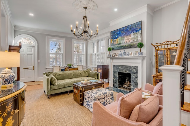 living room with a premium fireplace, a notable chandelier, and crown molding