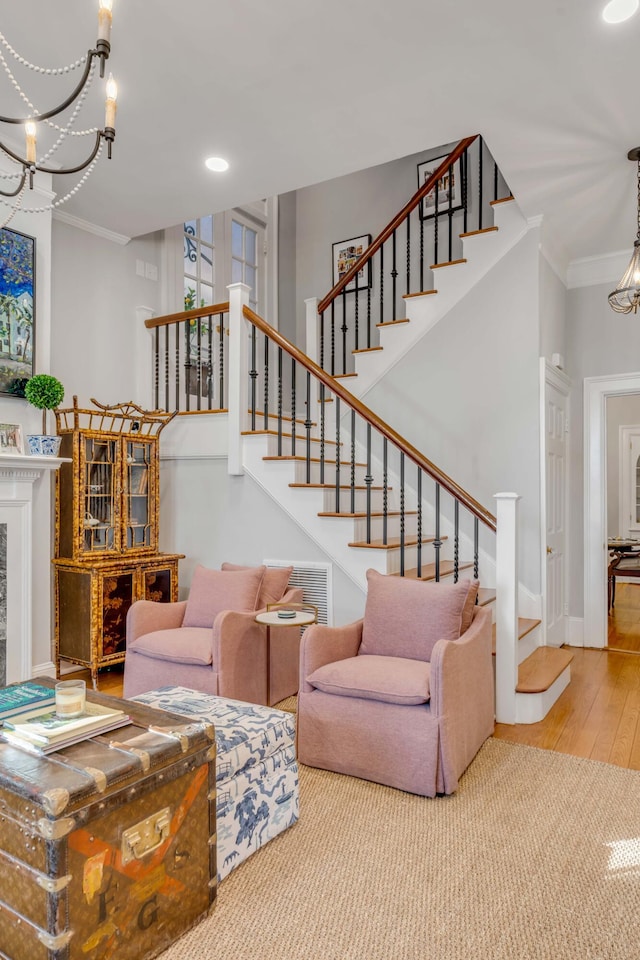 living room with hardwood / wood-style flooring, ornamental molding, and a chandelier