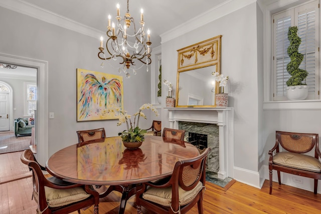 dining space featuring crown molding, a high end fireplace, and light hardwood / wood-style floors