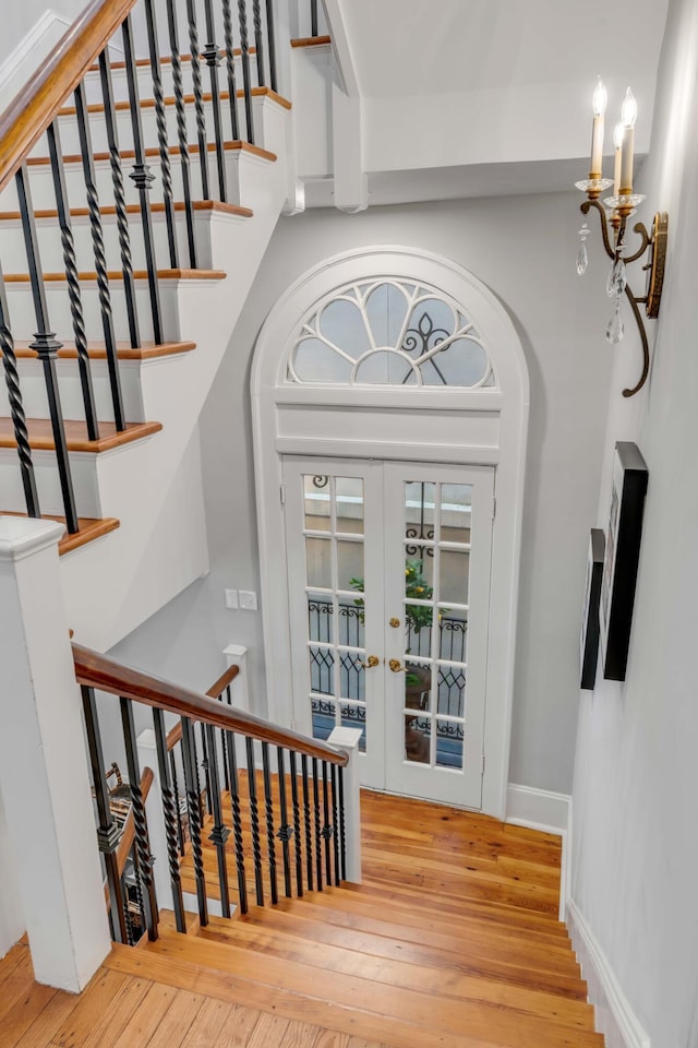 staircase featuring hardwood / wood-style floors and french doors