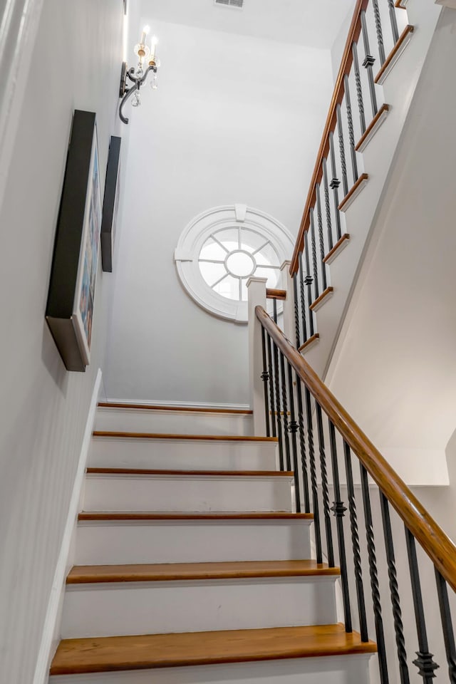 staircase featuring a chandelier