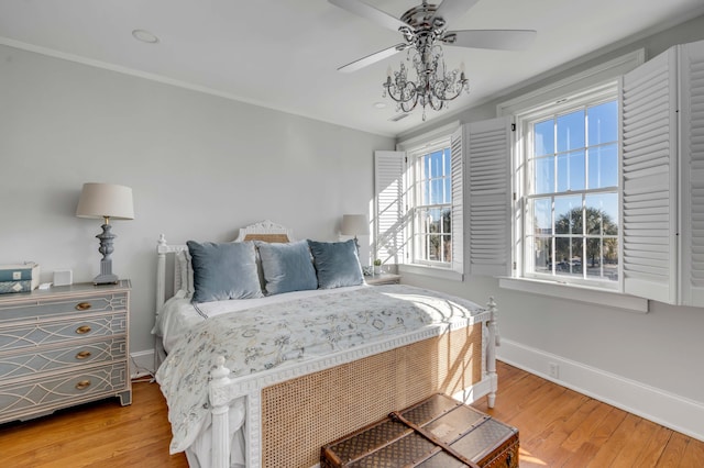 bedroom with hardwood / wood-style floors, crown molding, and ceiling fan