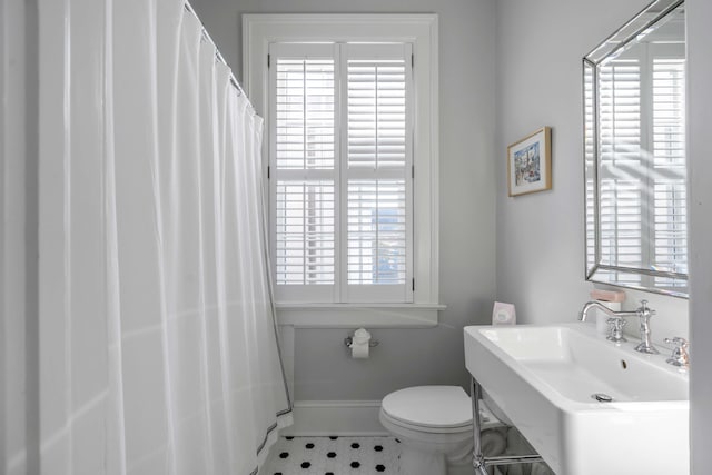 bathroom featuring toilet, tile patterned flooring, and sink