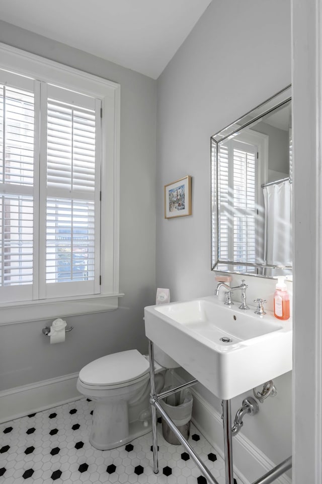 bathroom with a healthy amount of sunlight, tile patterned floors, and toilet