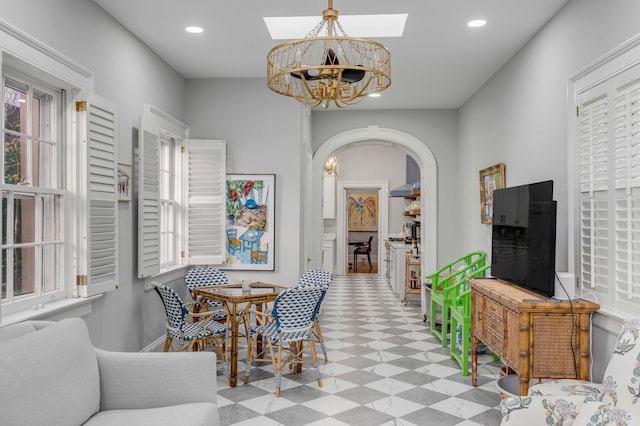 dining area featuring a skylight and a chandelier