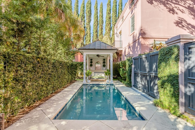 view of swimming pool featuring ceiling fan and a patio area