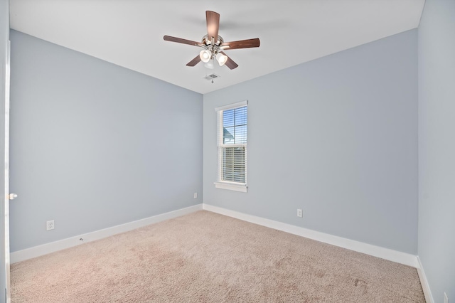 carpeted spare room with ceiling fan