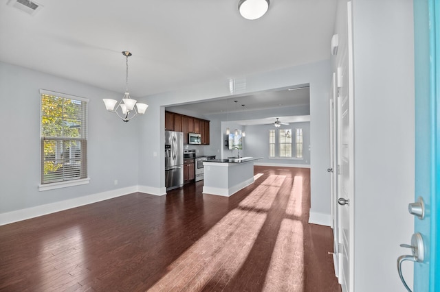 kitchen featuring kitchen peninsula, dark hardwood / wood-style flooring, plenty of natural light, and appliances with stainless steel finishes