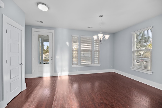 interior space featuring dark hardwood / wood-style floors, an inviting chandelier, and plenty of natural light