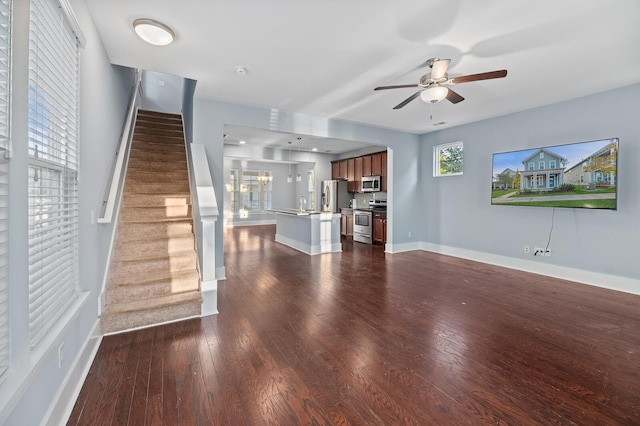 unfurnished living room featuring ceiling fan and dark wood-type flooring