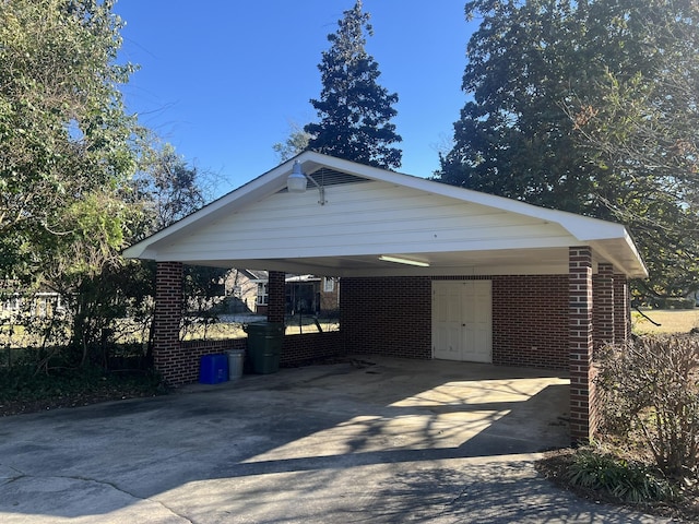 exterior space featuring concrete driveway, a carport, and brick siding