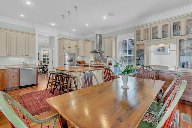 dining space with light hardwood / wood-style flooring and crown molding