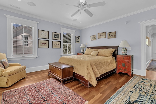 bedroom featuring multiple windows, hardwood / wood-style floors, ceiling fan, and crown molding