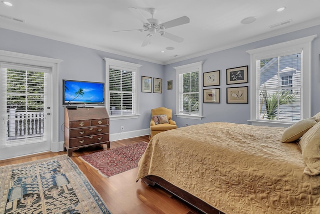 bedroom with crown molding, hardwood / wood-style flooring, multiple windows, and access to exterior