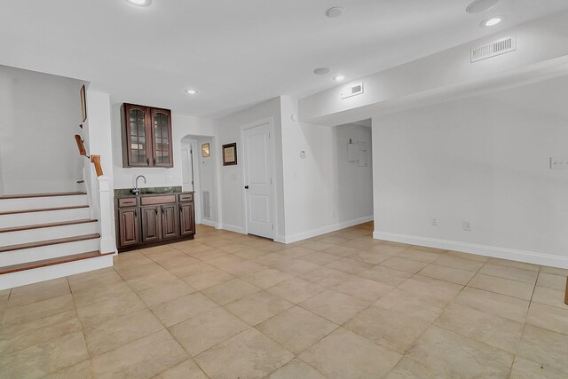 unfurnished living room with sink and light tile floors