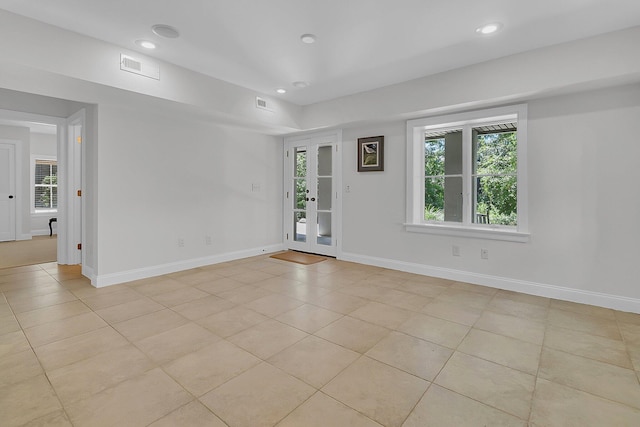 empty room featuring a wealth of natural light and light tile flooring