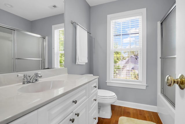 bathroom featuring vanity, toilet, baseboards, wood finished floors, and visible vents
