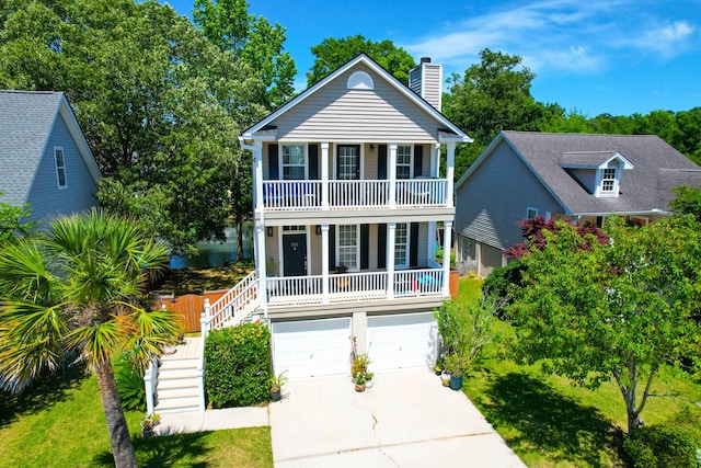 view of front of house with a porch, driveway, a chimney, a balcony, and stairs