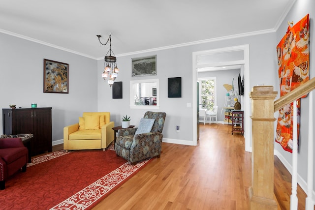 living area featuring crown molding, baseboards, wood finished floors, and stairway