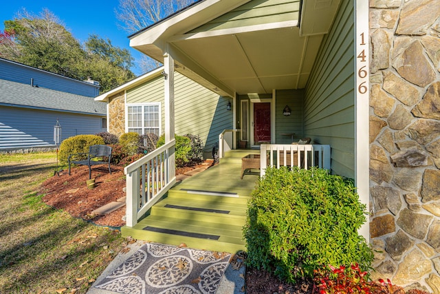 entrance to property with covered porch and stone siding