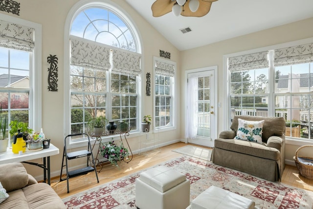 sunroom featuring lofted ceiling, a ceiling fan, and visible vents