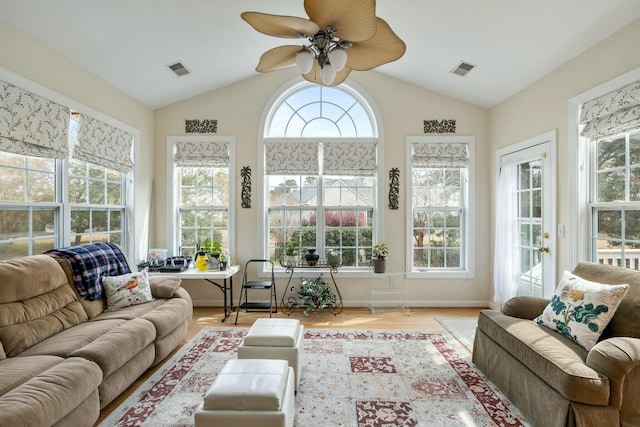 sunroom with a wealth of natural light, visible vents, lofted ceiling, and a ceiling fan