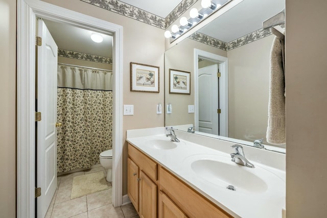 bathroom featuring double vanity, tile patterned floors, toilet, and a sink